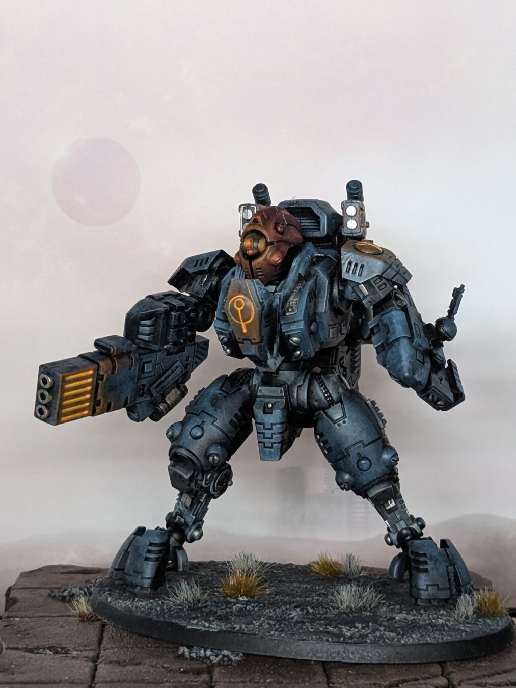 A photograph of a painted Warhammer 40,000 miniature. A Tau Ghostkeel suit in a shadowy color scheme.